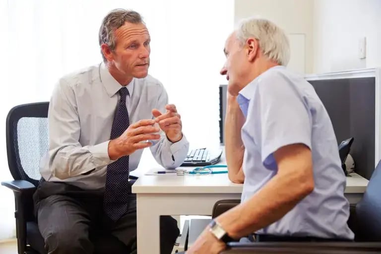 iStock-489349422-Senior-Patient-Having-Consultation-With-Doctor-In-Office-stock-photo-768x512